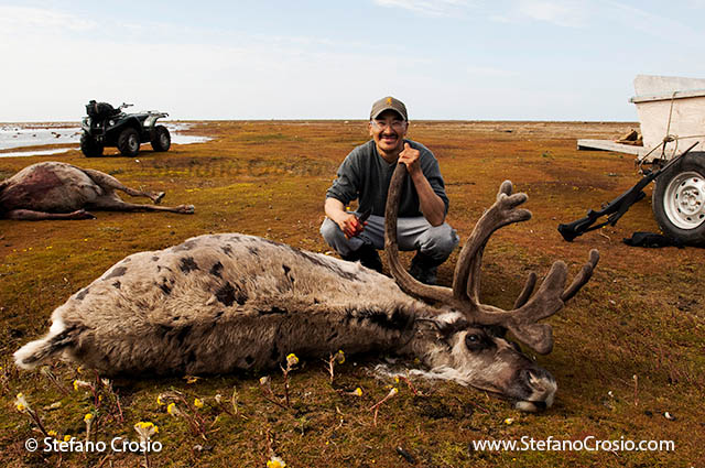 CANADA, Nunavut Inuit hunter with his caribou prey